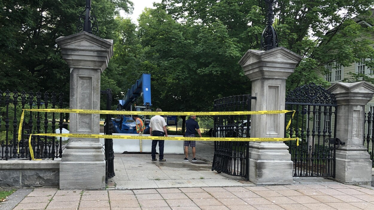 Une équipe installe la barrière de béton à l'aide de machinerie.