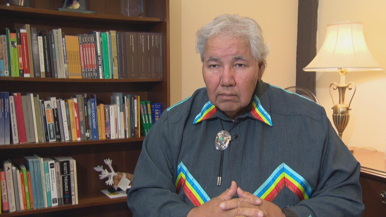 Le sénateur Murray Sinclair devant une bibliothèque et une lampe.