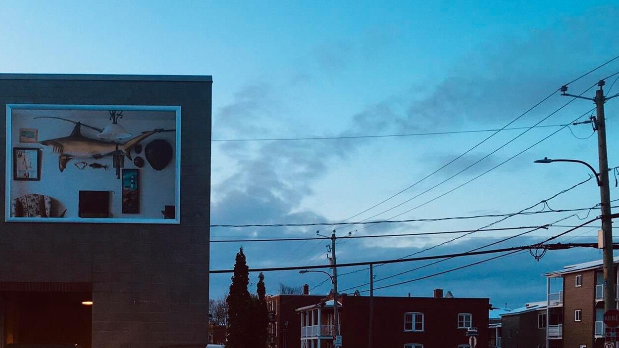 Une oeuvre d'art, posée sur un mur de béton, dans une rue du centre-ville de Drummondville.