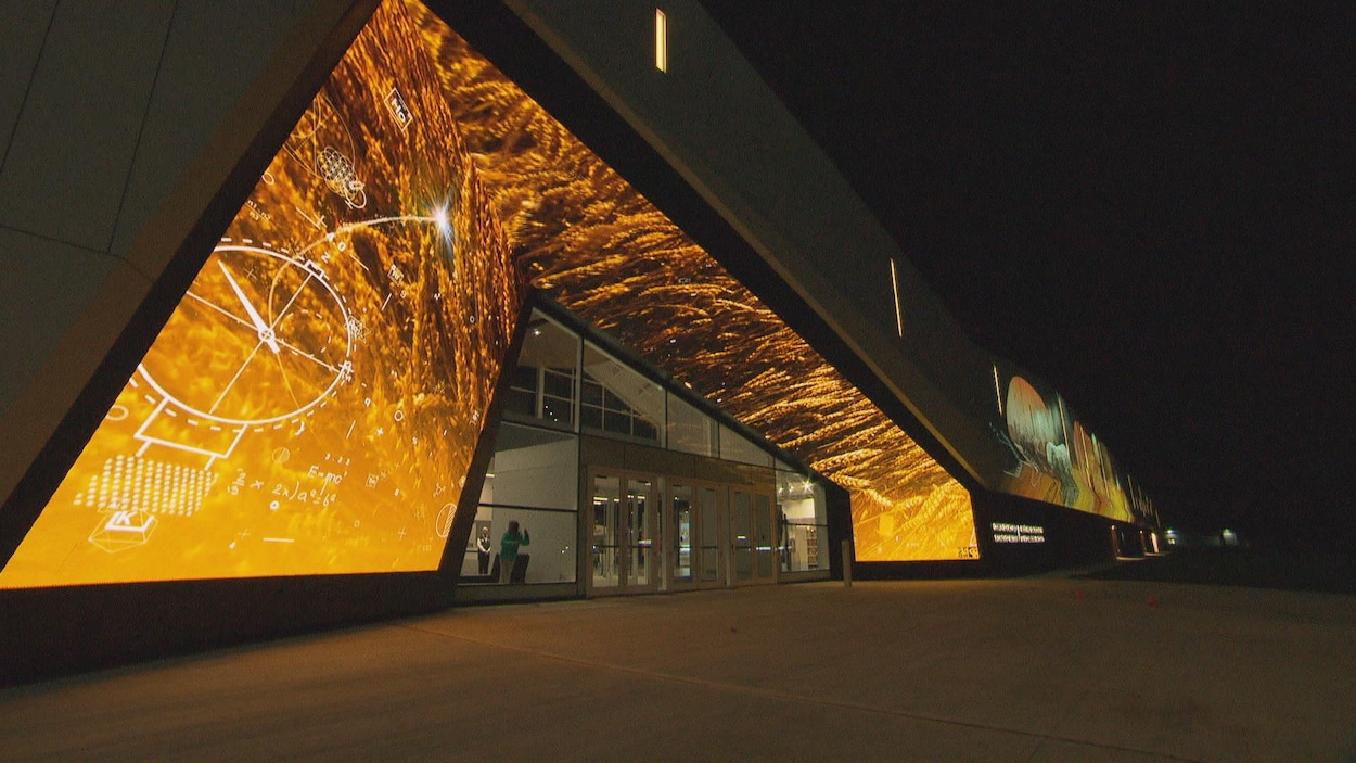 La devanture d'un musée prise le soir est illuminée par un écran de projection aux teintes dorées. La devanture d'un musée prise le soir est illuminée par un écran de projection aux teintes dorées.