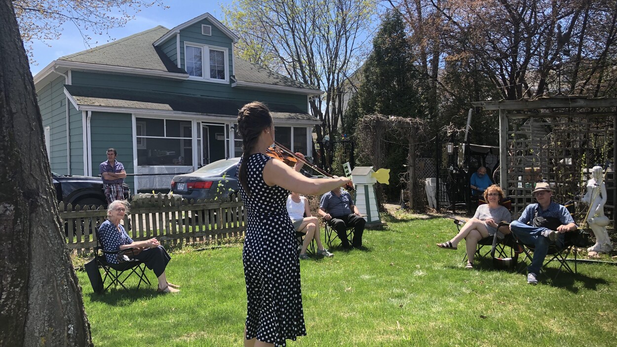 Une musicienne offre un concert dans un jardin.