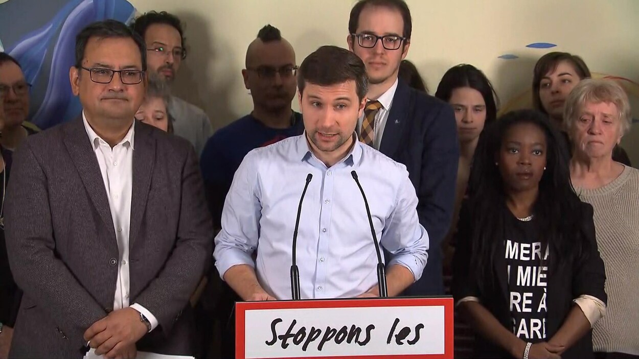 Gabriel Nadeau-Dubois parle dans un micro placé sur un lutrin.