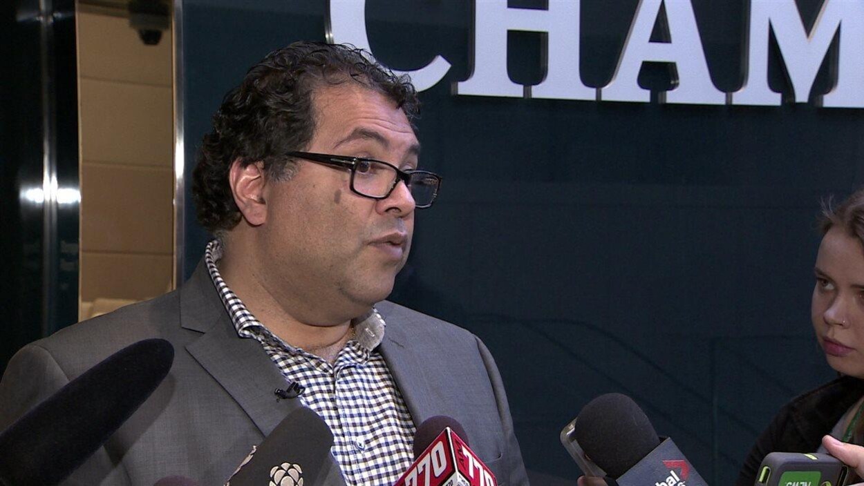 Naheed Nenshi répond aux journalistes devant la porte du conseil municipal. Naheed Nenshi répond aux journalistes devant la porte du conseil municipal.