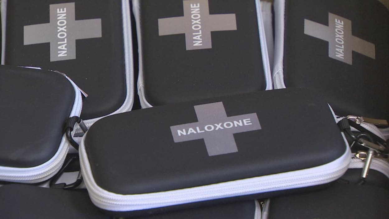 Photo de trousses noires marquées d'une croix avec la mention naloxone.