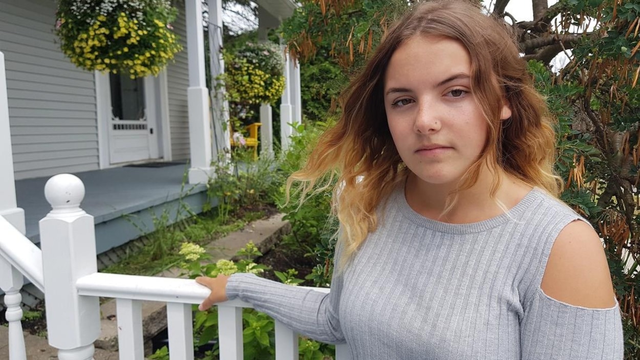 Photo d'une adolescente qui tient la rampe d'un escalier à l'extérieur.