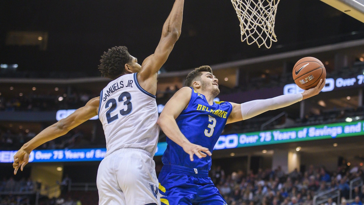 Nate Darling lève le ballon vers le panier dans un match de basketball.