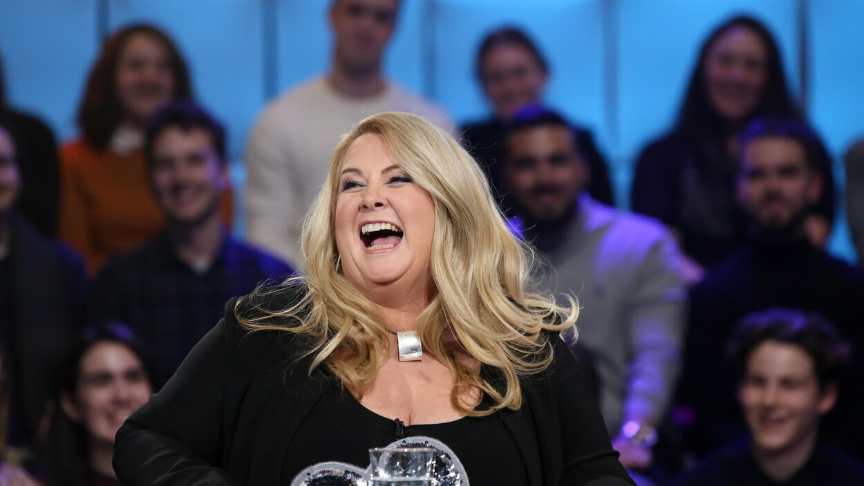 La femme blonde éclate de rire.