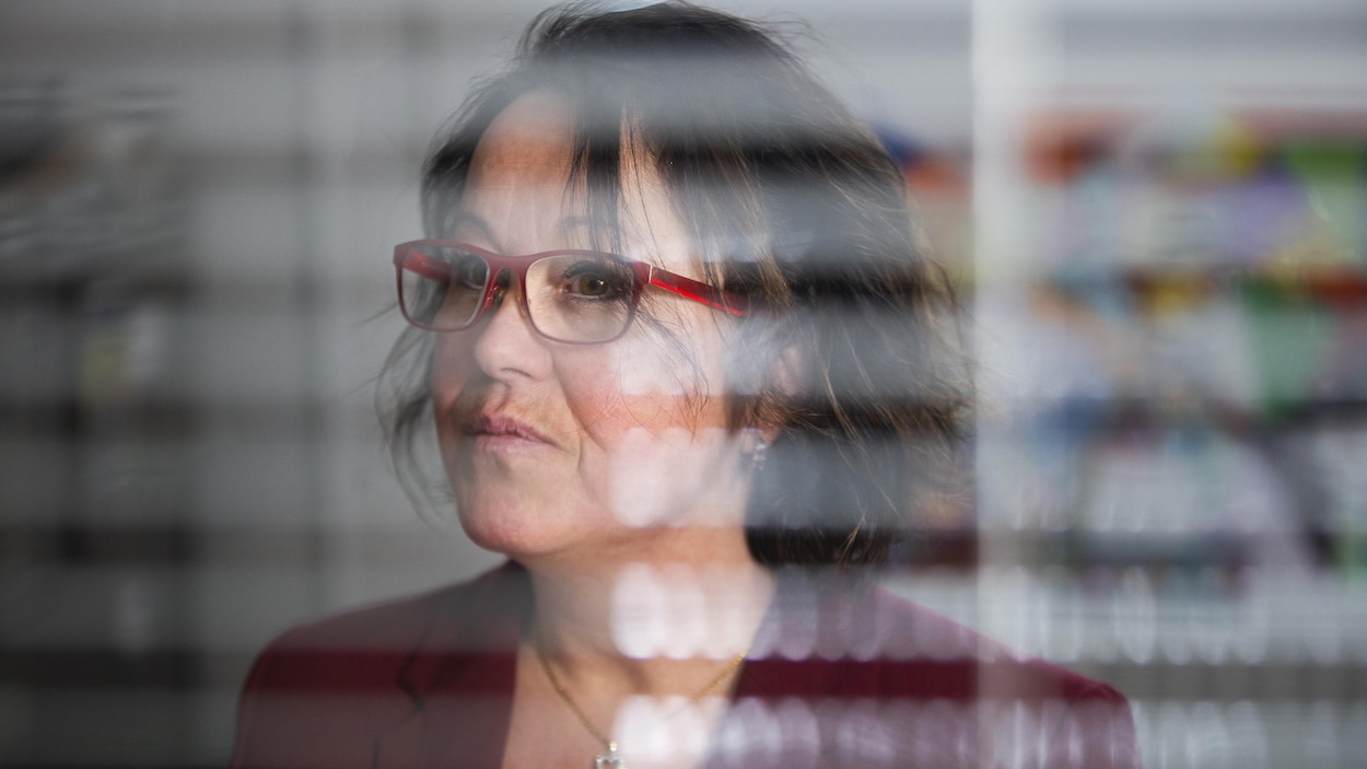 Nathalie Trottier porte un veston rouge sur lequel est épinglé un ruban blanc, signe de solidarité avec les victimes de Polytechnique.