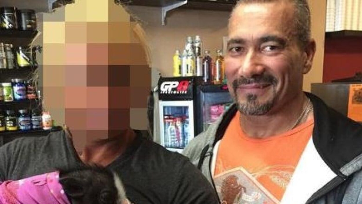 Photographie du policier en compagnie d'une autre personne dont le visage est flouté.