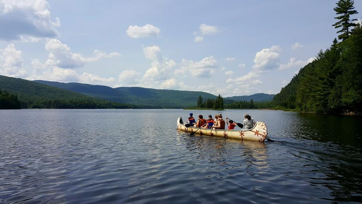 Des utilisateurs de Navette Nature en rabaska sur un lac.