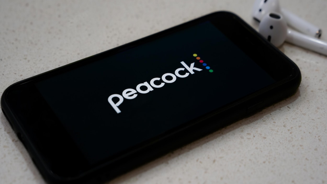 Un écran de cellulaire sur lequel apparaît le logo de Peacock.