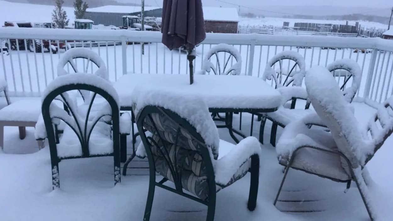 Des chaises et une table recouvertes de neige.