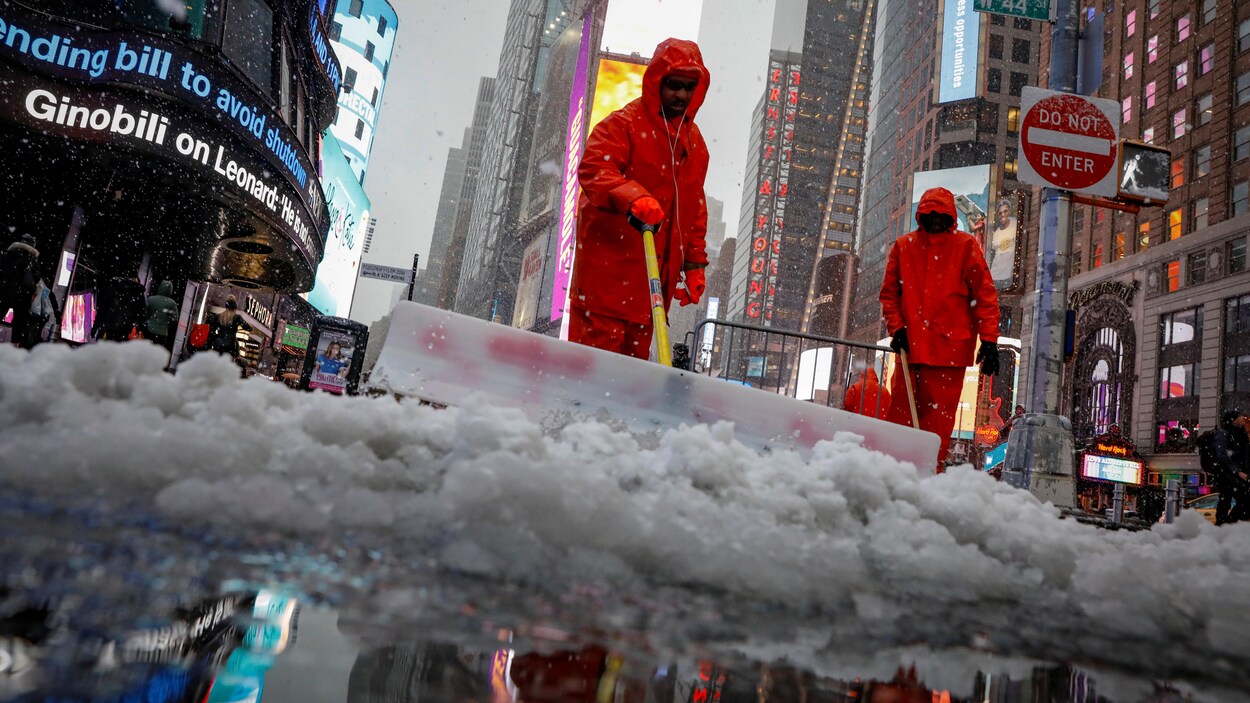 Des hommes dégagent de la neige dans la rue. Des hommes dégagent de la neige dans la rue.