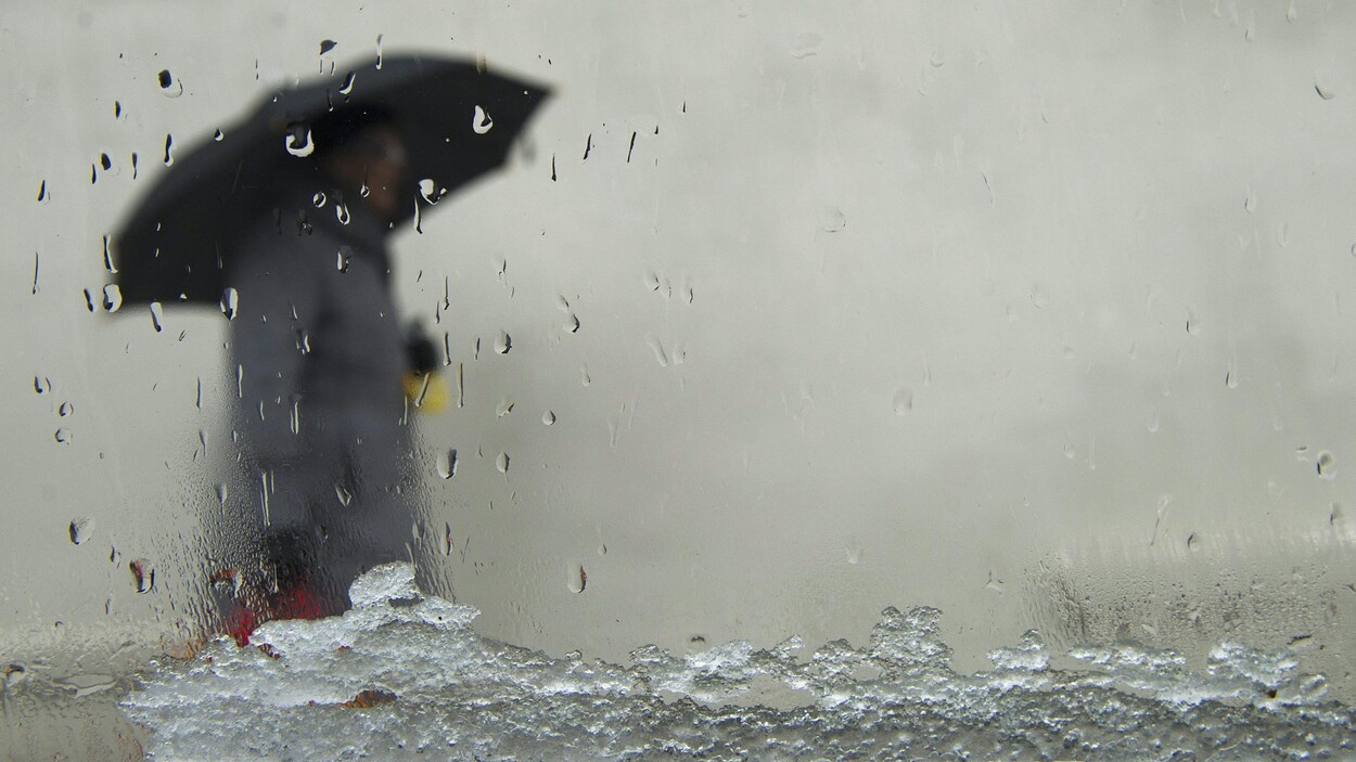 Mélange de neige et de pluie observé à travers le pare-brise d'une automobile.