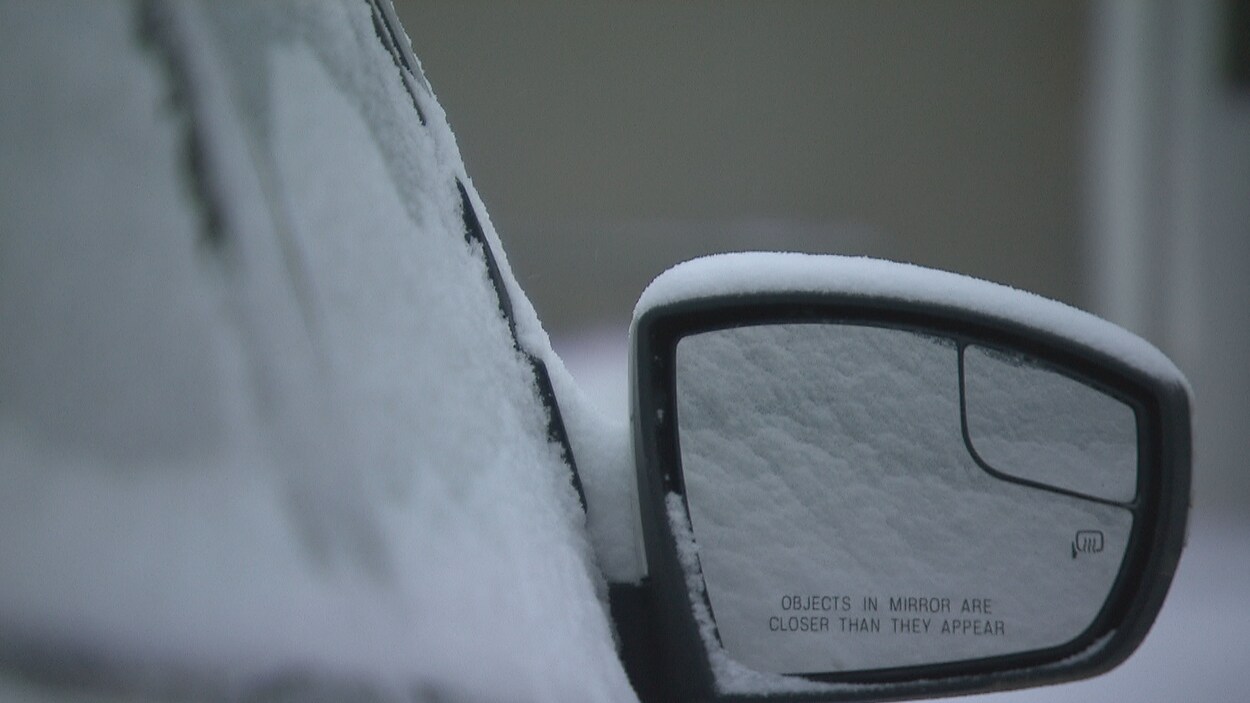 De la neige recouvre une voiture.