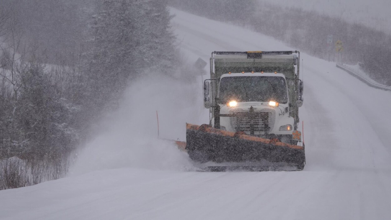 Une déneigeuse pendant une tempête de neige