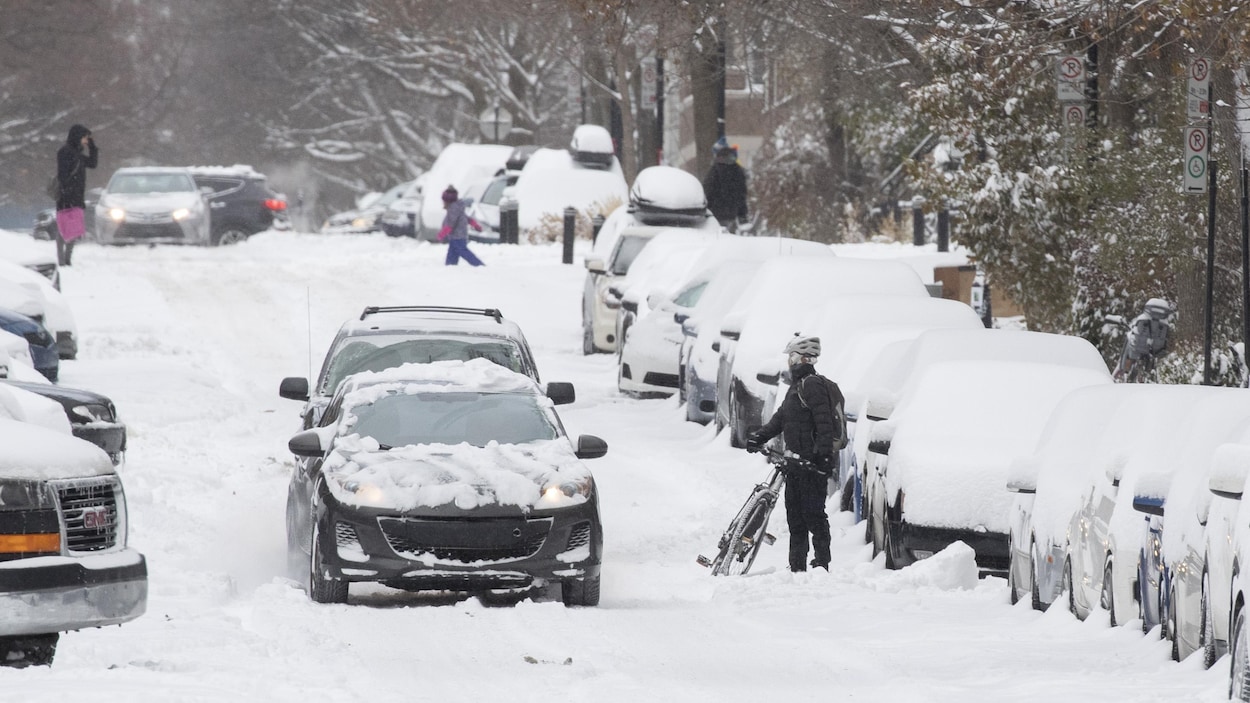 Une rue de Montréal et des voitures ensevelies sous la neige.