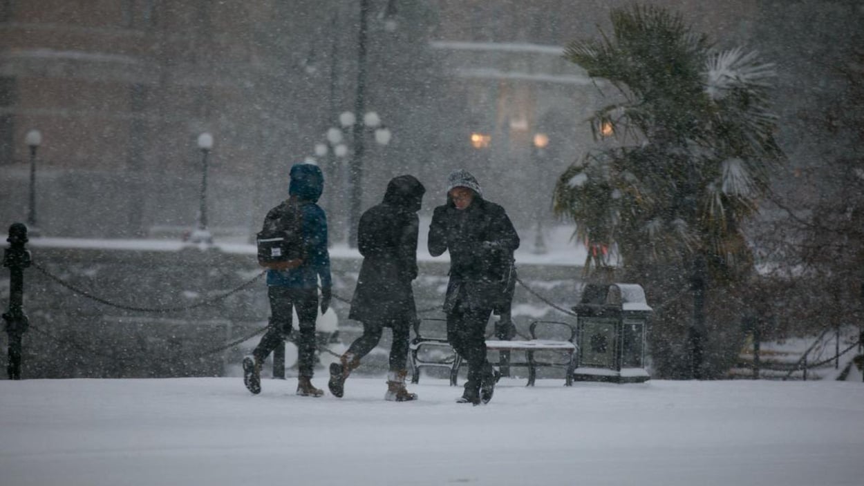Des gens marchent dans la neige à Victoria.