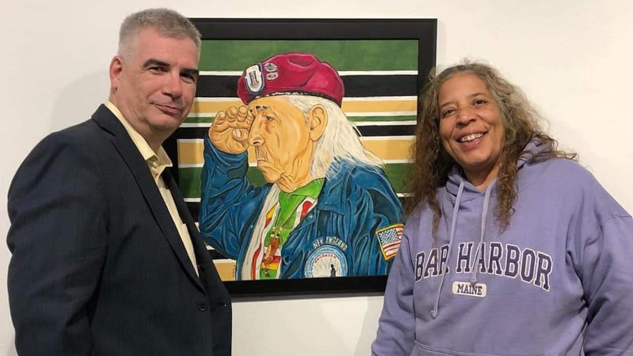 Nelson White pose avec une femme devant son tableau Elder Veteran.