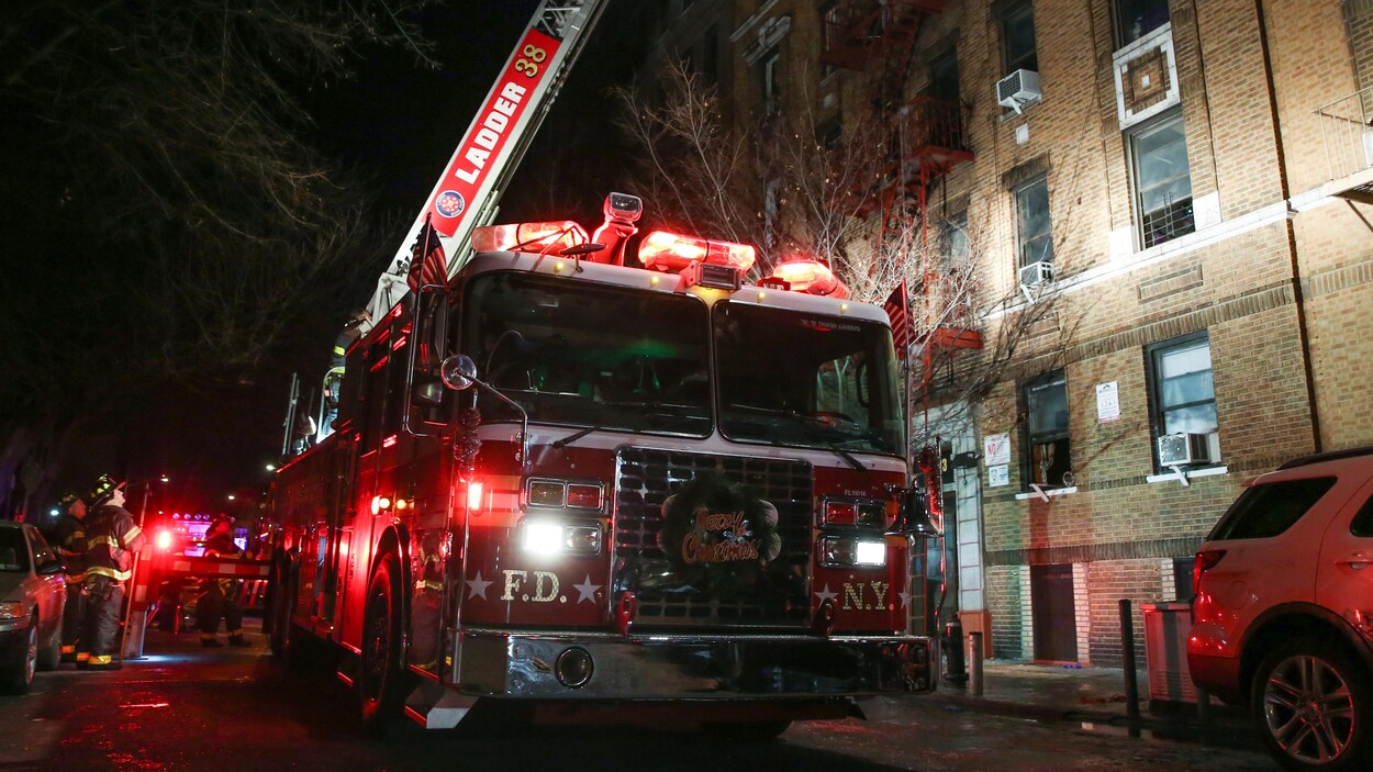 L'échelle d'un camion de pompier est déployée au-dessus de l'immeuble en flammes. L'échelle d'un camion de pompier est déployée au-dessus de l'immeuble en flammes.