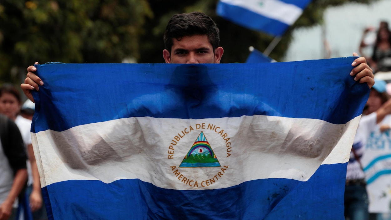 Un homme tient un drapeau national pendant une marche en soutien aux étudiants universitaires qui protestent contre le gouvernement du président nicaraguayen Daniel Ortega à Managua. Un homme tient un drapeau national pendant une marche en soutien aux étudiants universitaires qui protestent contre le gouvernement du président nicaraguayen Daniel Ortega à Managua.