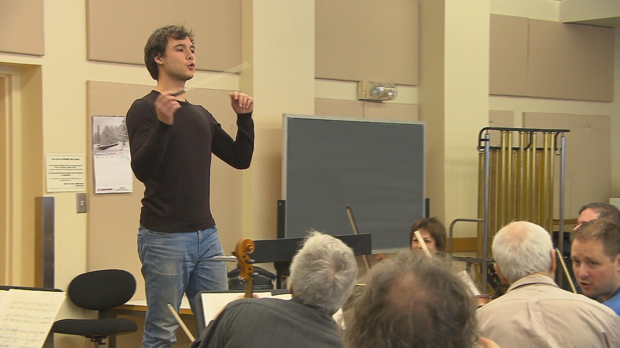 Un chef d'orchestre devant des musiciens