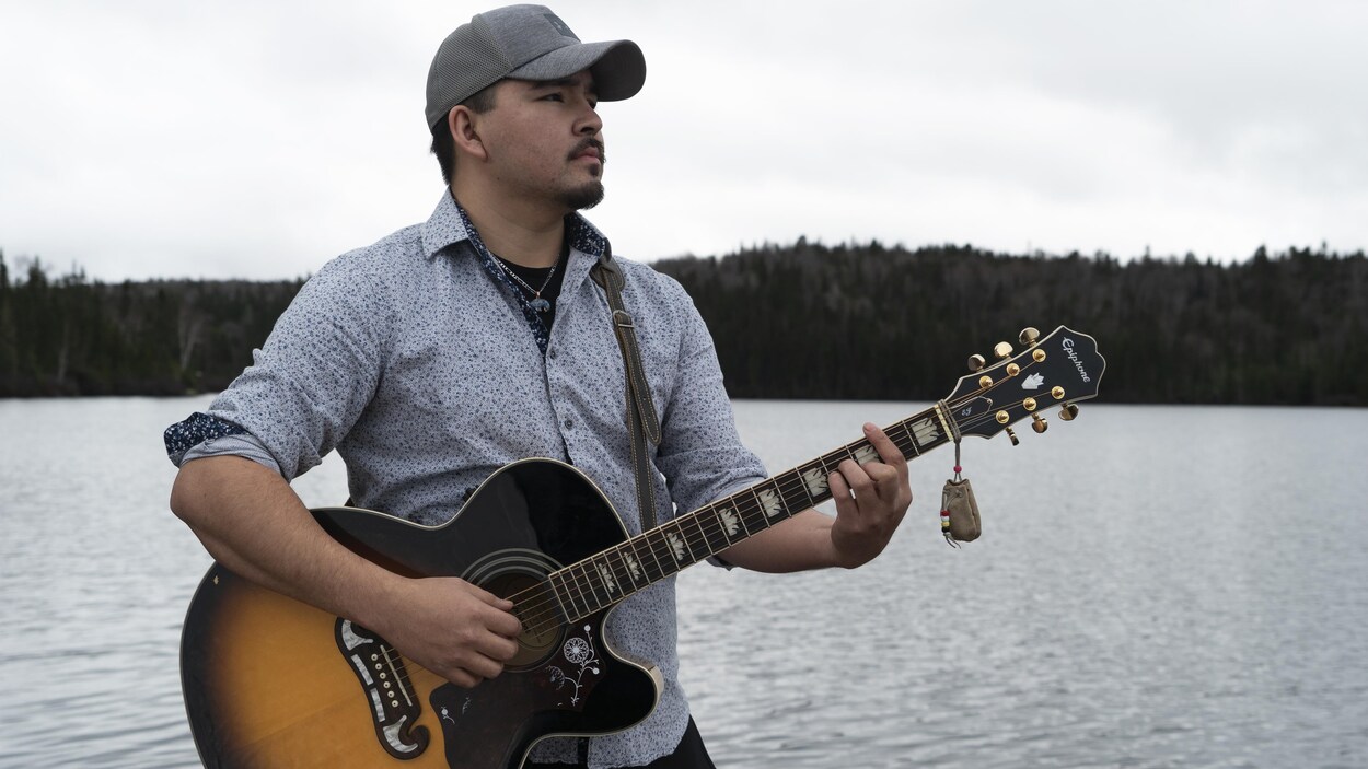 Un jeune homme joue de la guitare.