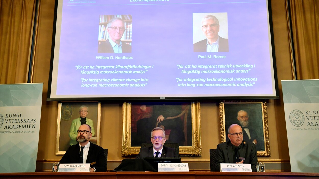 Trois hommes présentent les lauréats avec un support audiovisuel.