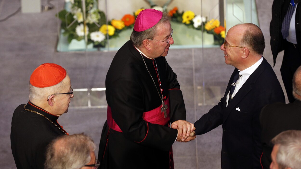 L'homme d'église serre la main du premier ministre.