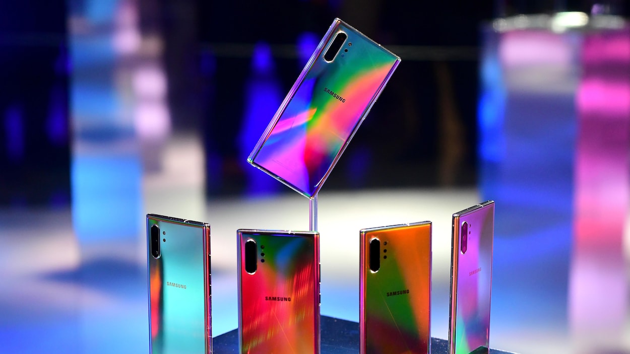 Une photo de cinq téléphones Note 10. Quatre sont disposés debout en demi-cercle et le cinquième est surélevé au bout d'une tige de verre.