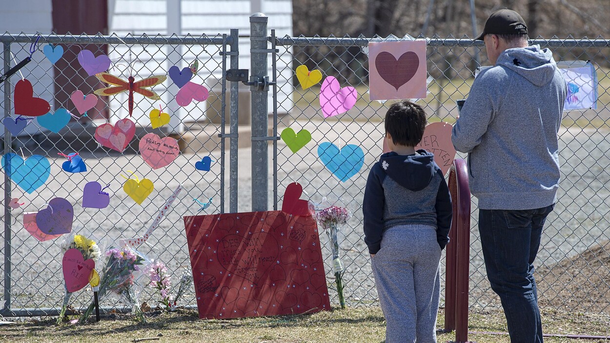 Un homme et son fils sont venus rendre hommage à Lisa McCully, qui enseignait à l'école primaire Debert, mardi. Mme McCully est l'une des 22 victimes de la tuerie de dimanche.