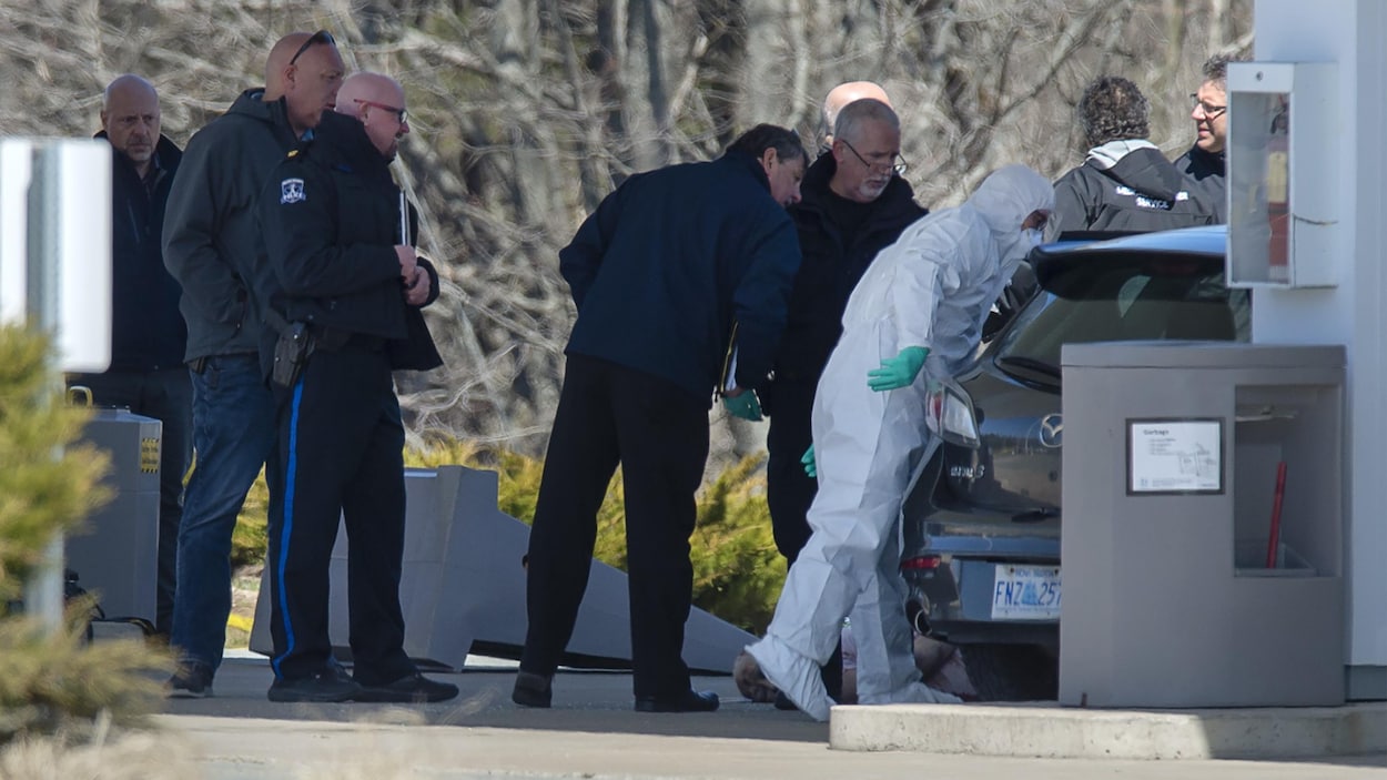 Des agents observent une voiture dans une station-service.