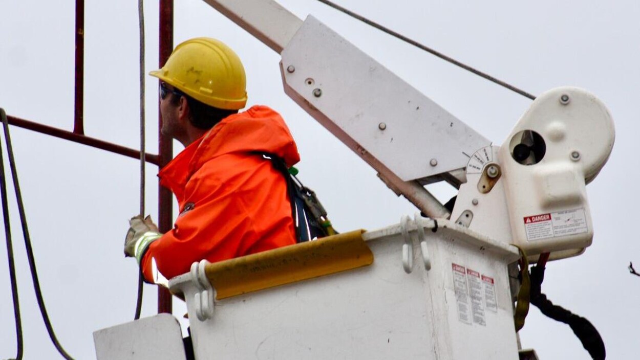 Un travailleur de la compagnie d'électricité dans une nacelle.