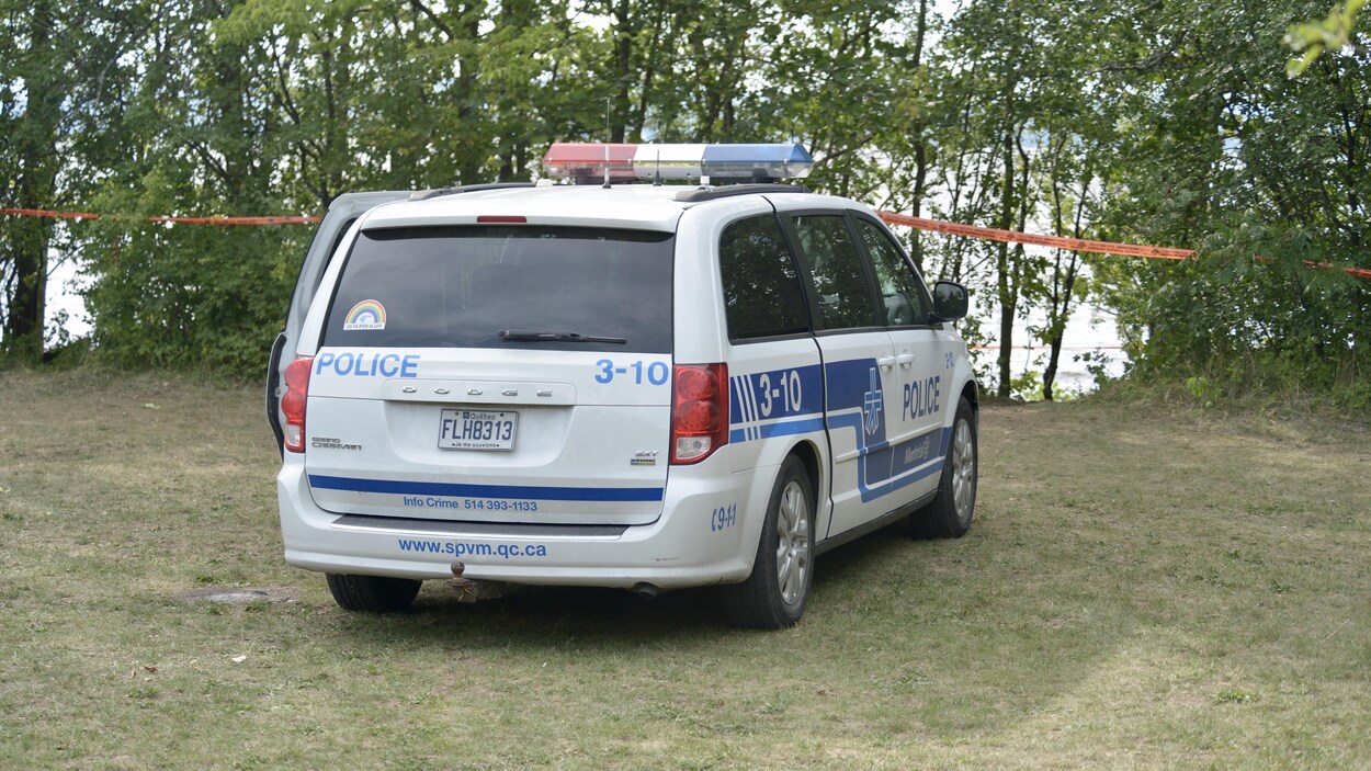 Une voiture de police devant la rive.