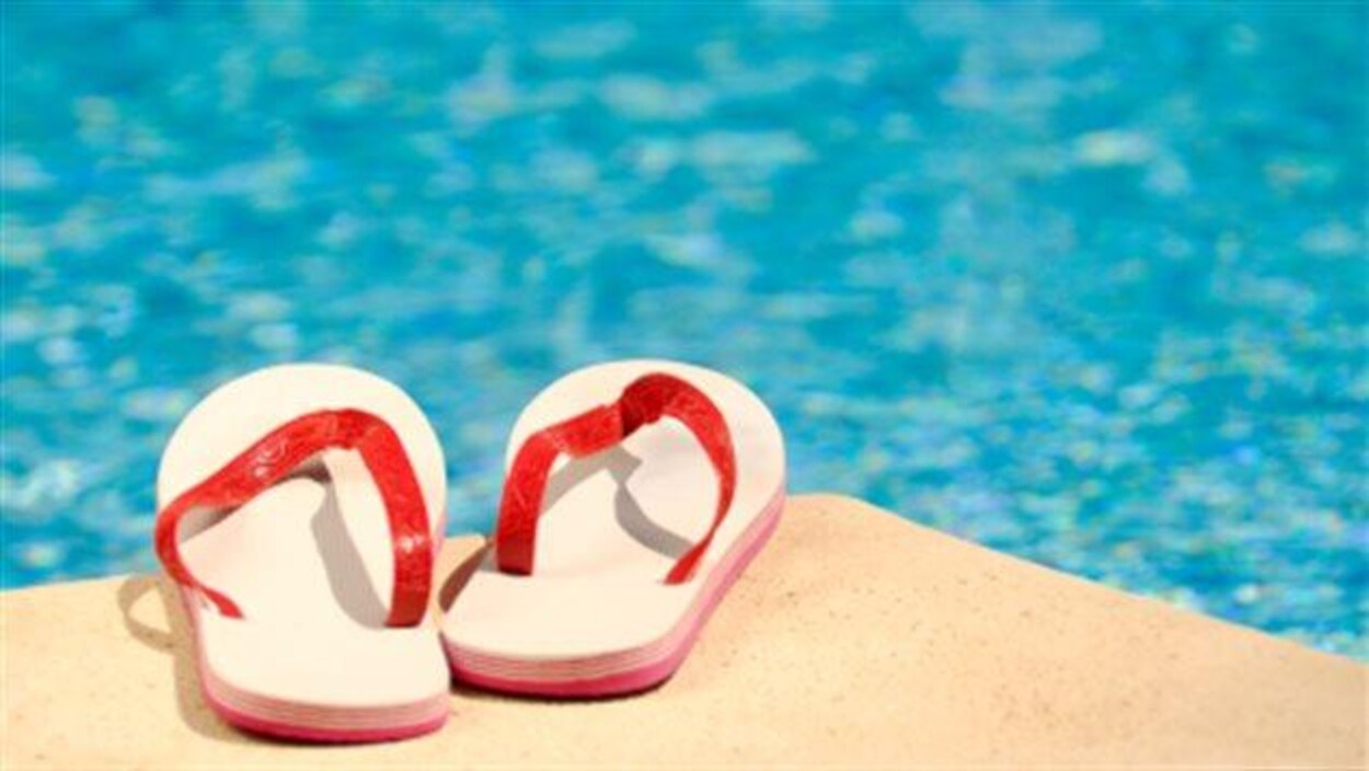 Des sandales sur le bord d'une piscine