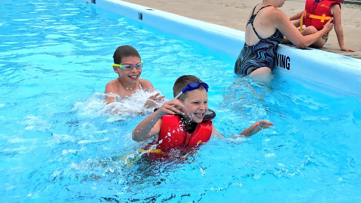 Des enfants jouent dans une piscine.