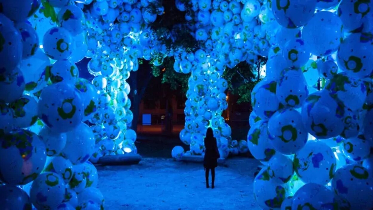 Une femme dans une installation artistique la nuit.