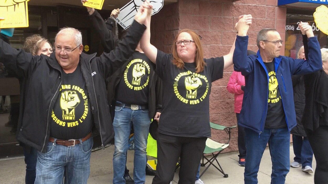 Les chefs syndicaux du SCFP lèvent les bras à leur sortie des bureaux de la ministre Dorothy Shephard, le 4 mai 2019 à Fredericton.