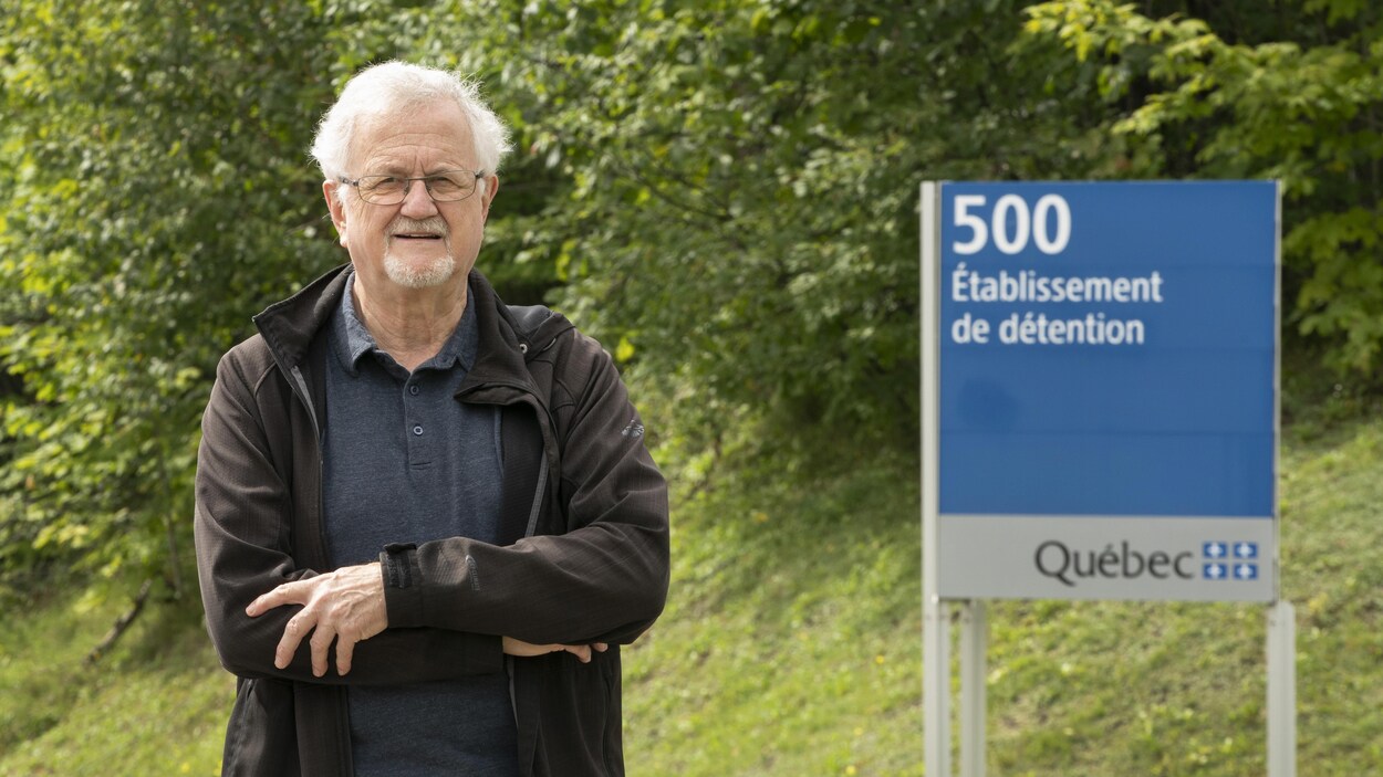 Serge Lépine devant une pancarte sur laquelle est inscrit : 500, Établissement de détention.