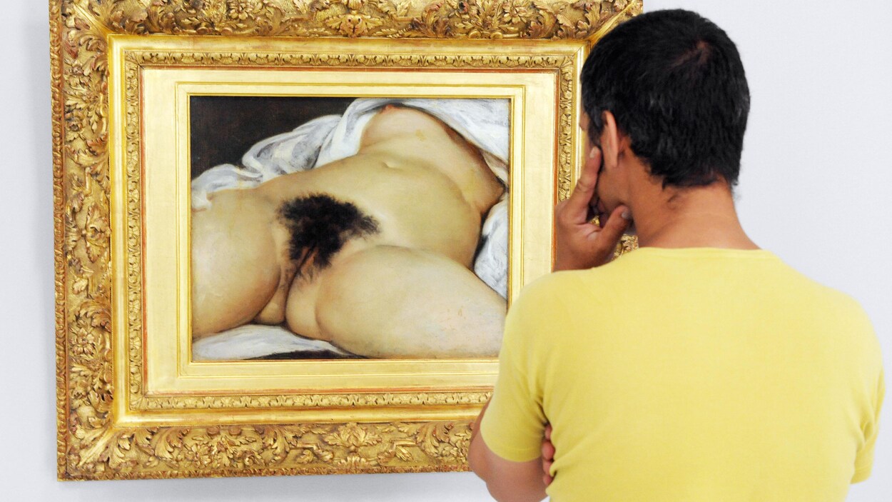 Un homme regarde le tableau L'Origine du monde