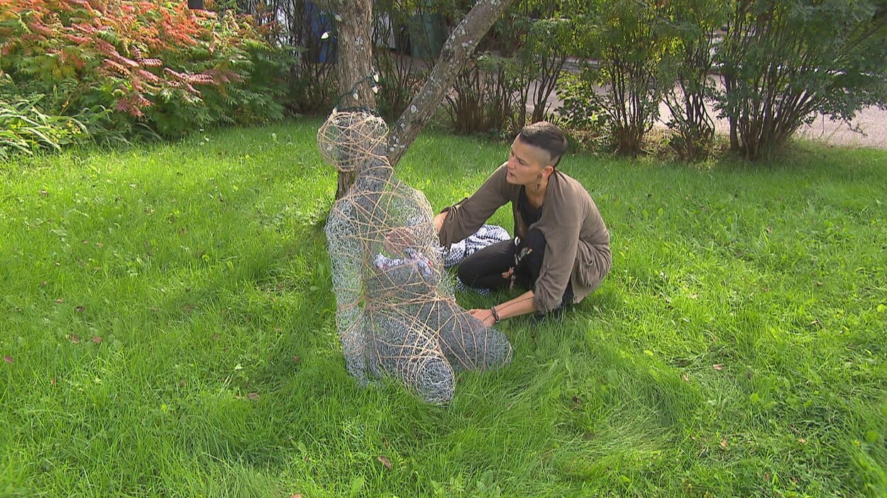 Une femme replace une sculpture.