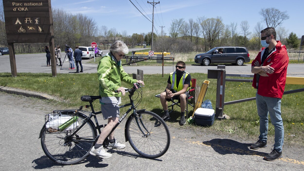 Une cycliste près d'une des entrées principales du parc d'Oka.