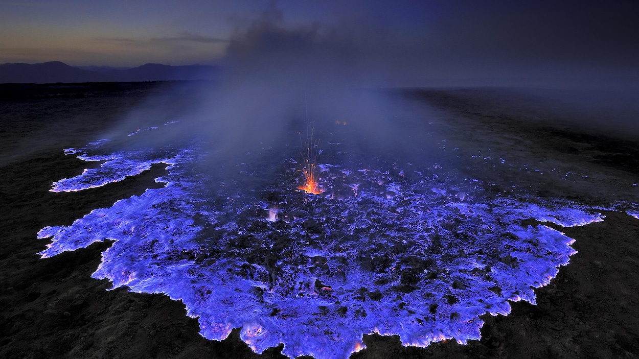 Une flaque bleue de lave s'écoule.