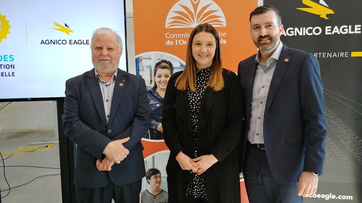 Gaétan Gilbert, Mélanie Corriveau et Jason Yergeau posent devant des affiches de leur employeur respectif.