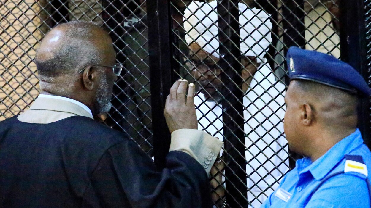 Omar El-Béchir est dans une cage grillagée.