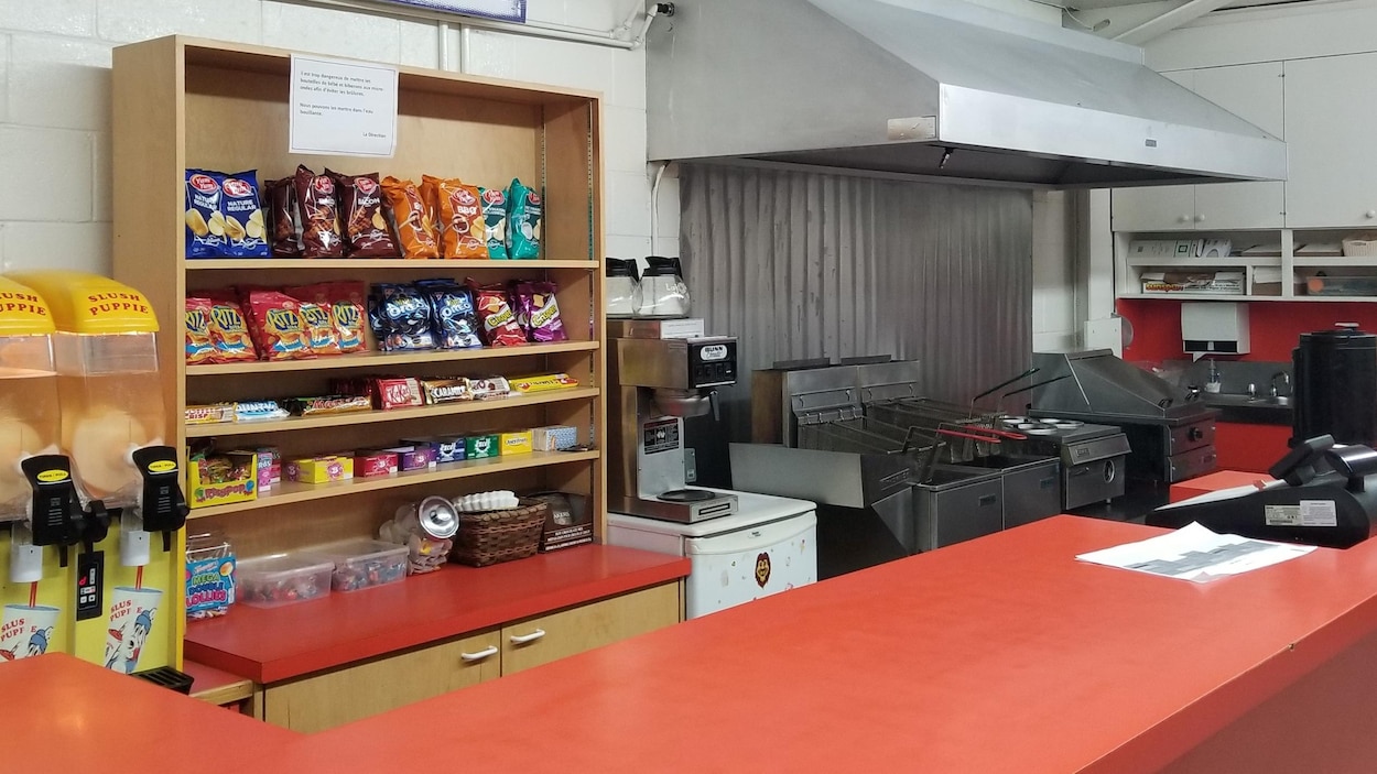 Une cuisine d'aréna avec une friteuse et une machine à barbotine.