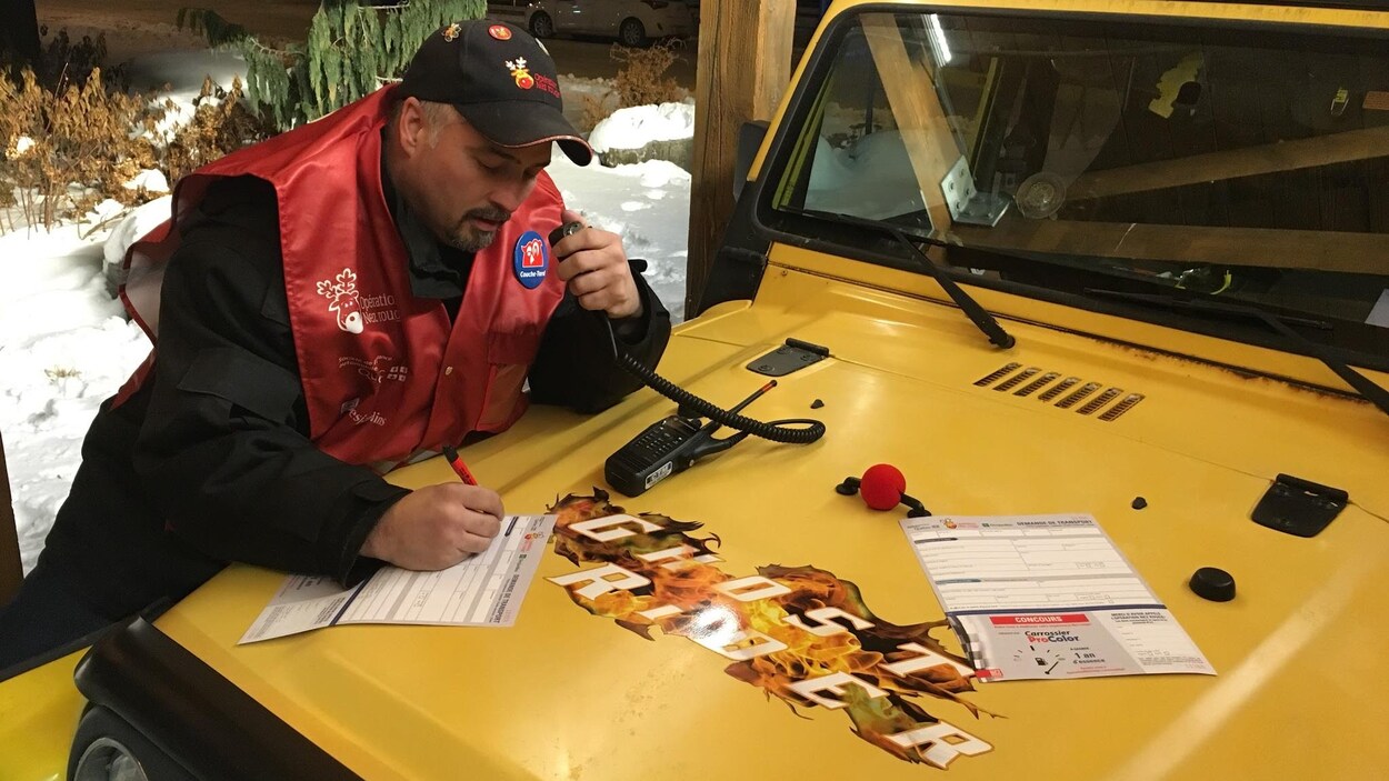 Un bénévole de l'Opération Nez rouge est en train de répondre à un appel tout en remplissant un formulaire.