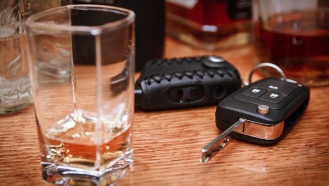 Des clés de voiture et un verre d'alcool.