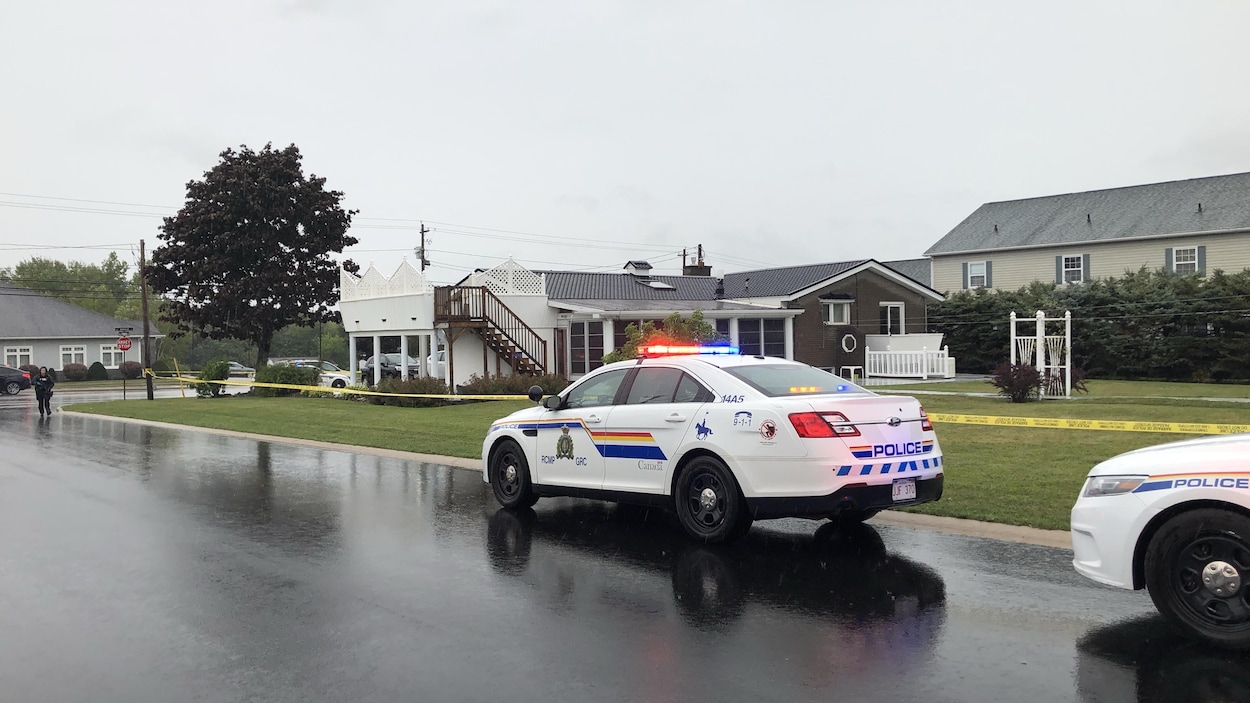 Des policiers devant des maisons.
