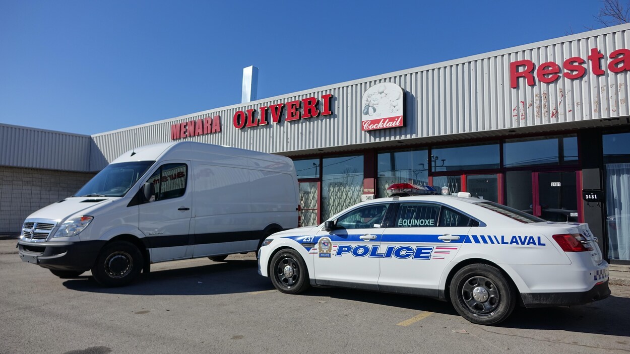 Une voiture de police stationnée devant un restaurant.